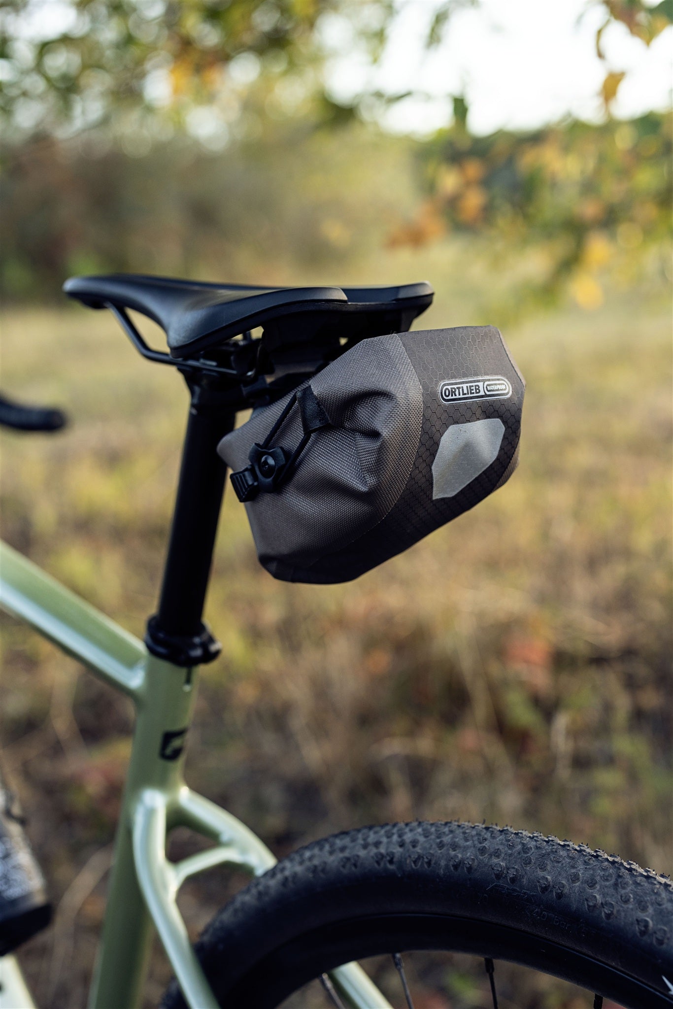 ORTLIEB Micro-Bag in dark-sand am Fahrradsattel montiert im natürlichen Umfeld